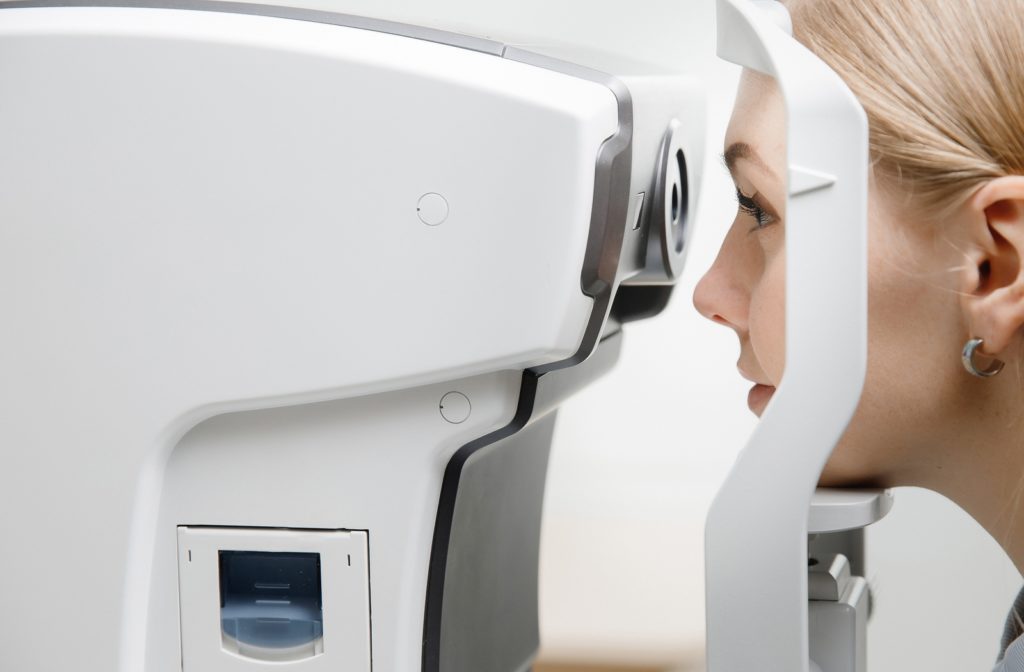 A woman at her optometrist completing an OCT (Optical Coherence Tomography) test to inspect her retina