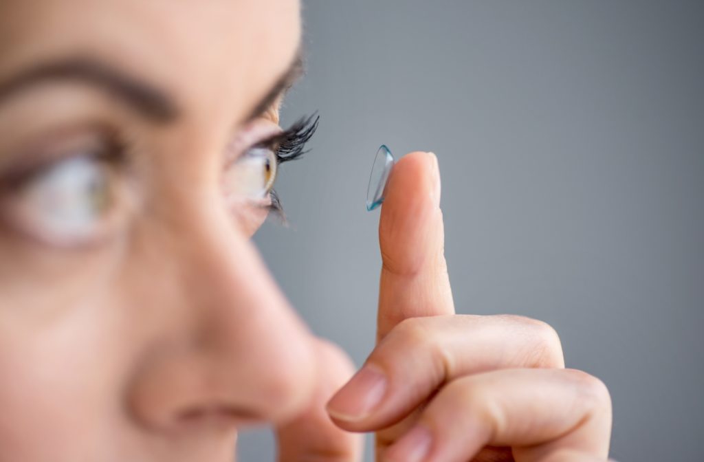 A close up side view of a women putting in a contact lens