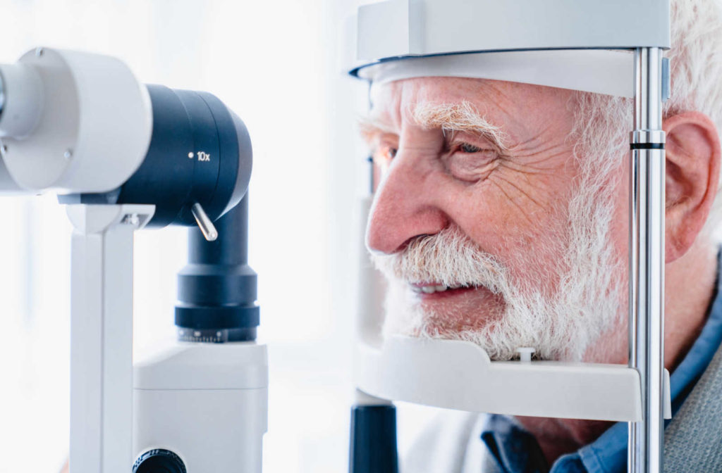 An older male patient getting his eyes tested during an eye exam.